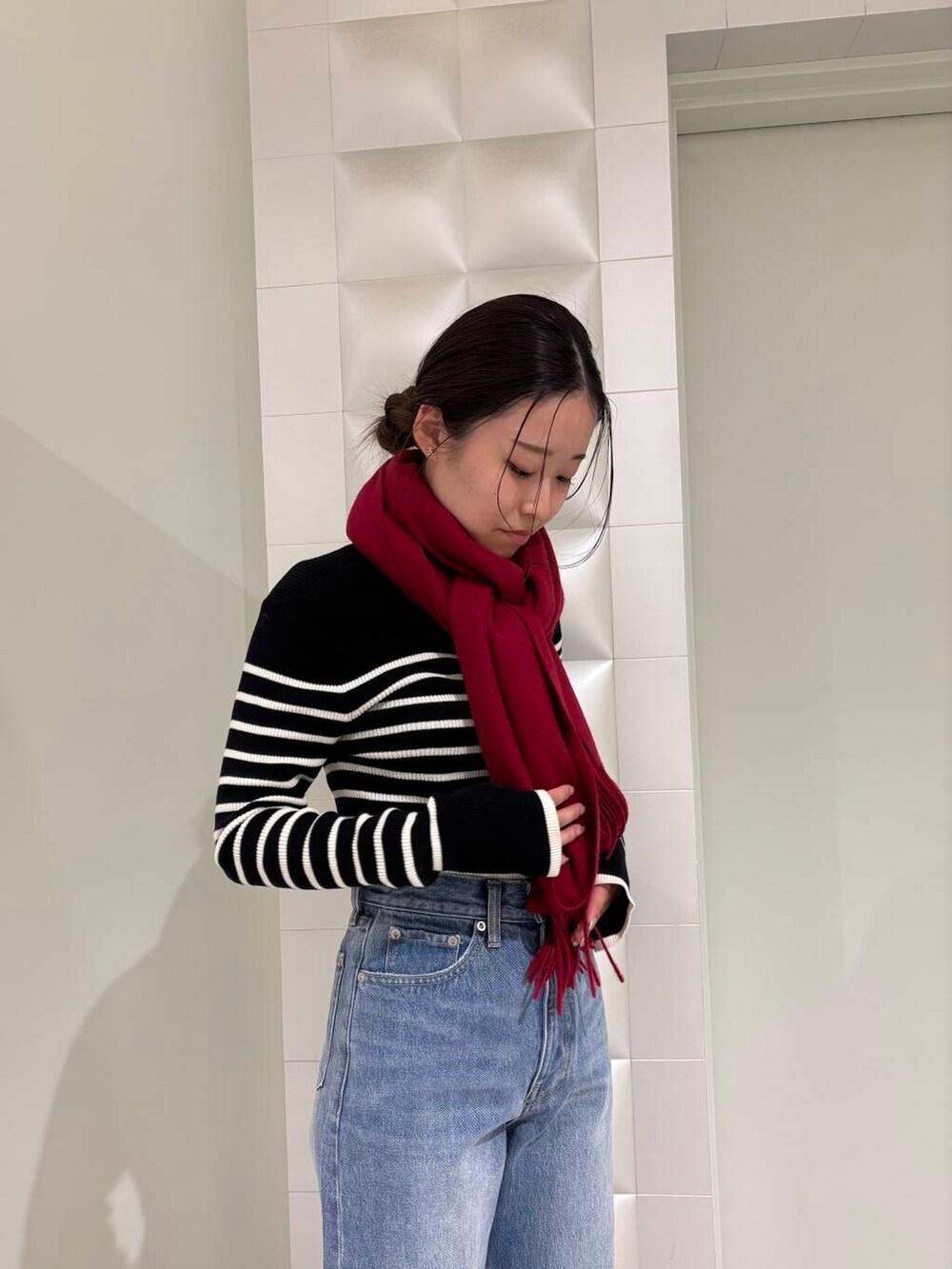 ブラック系のニット/セーター、ブルー系のデニムパンツ、ホワイト系のその他アウターを着用したレディースの秋コーディネートの5枚目の写真