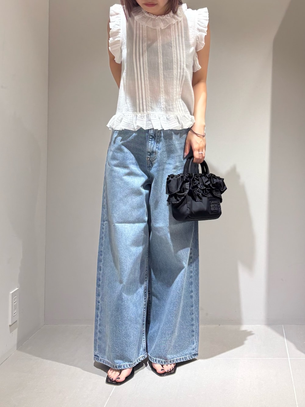 ホワイト系のシャツ/ブラウス、ブルー系のデニムパンツ、ブラック系のサンダルを着用したレディースの夏コーディネートの5枚目の写真