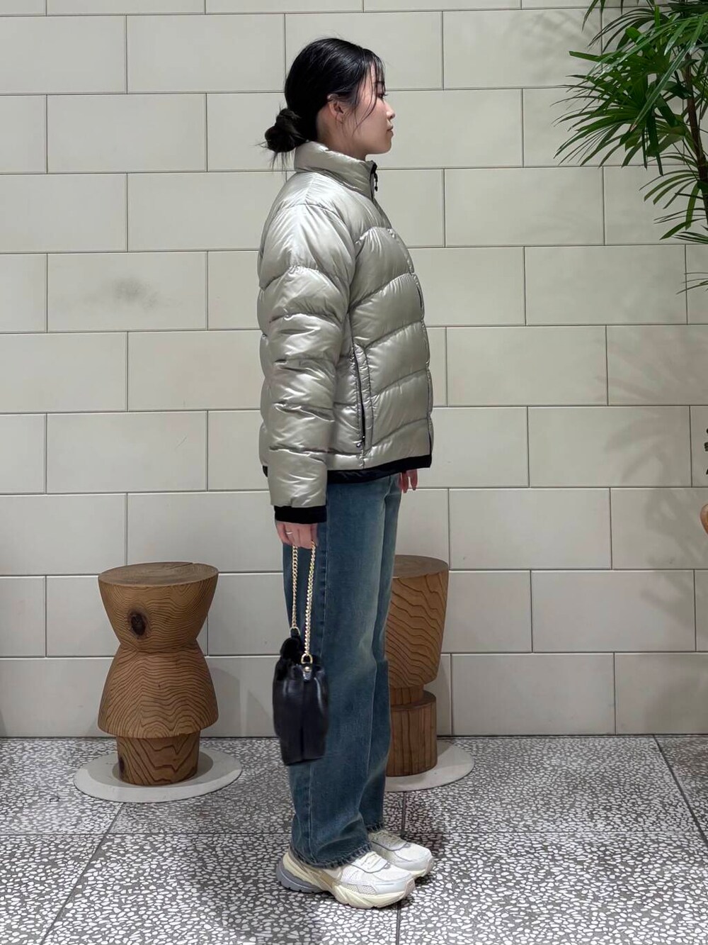 ホワイト系のスニーカー、グレー系のダウンジャケット/コート、ブルー系のデニムパンツを着用したレディースの冬コーディネートの3枚目の写真