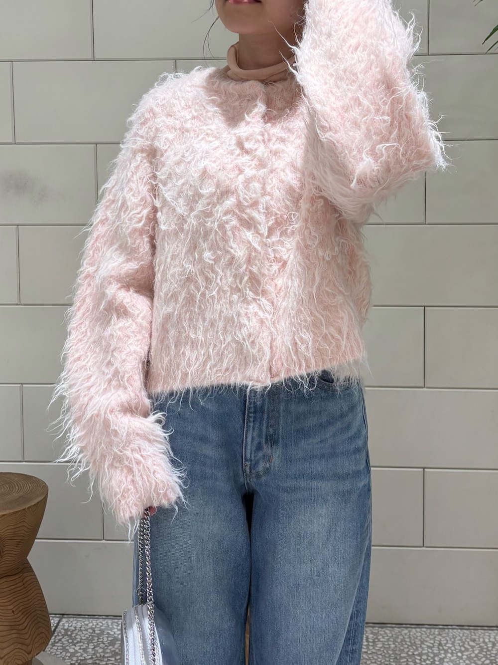 ピンク系のカーディガン/ボレロ、ピンク系のTシャツ/カットソー、ブルー系のデニムパンツを着用したレディースの冬コーディネートの2枚目の写真