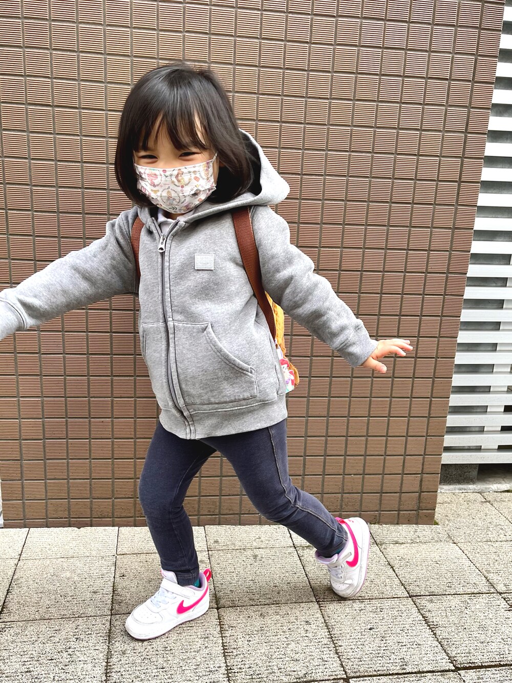 グレー系のパーカー、ホワイト系のスニーカーを着用したキッズの春コーディネートの2枚目の写真