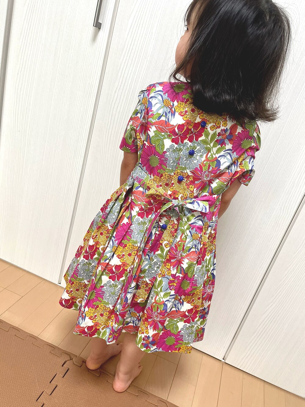 レッド系のワンピースを着用したキッズの春コーディネートの2枚目の写真