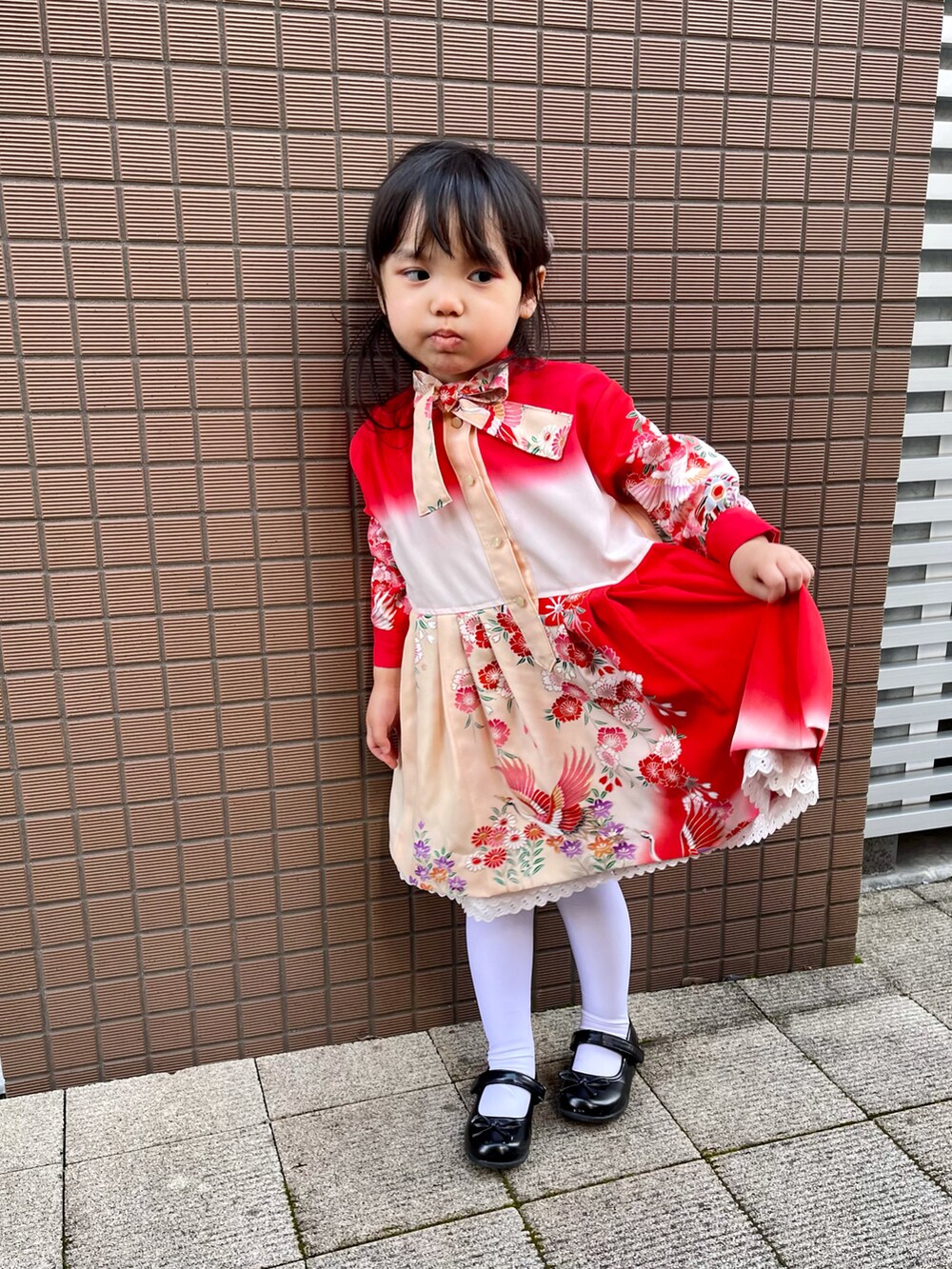 レッド系のワンピースを着用したキッズの秋コーディネートの2枚目の写真