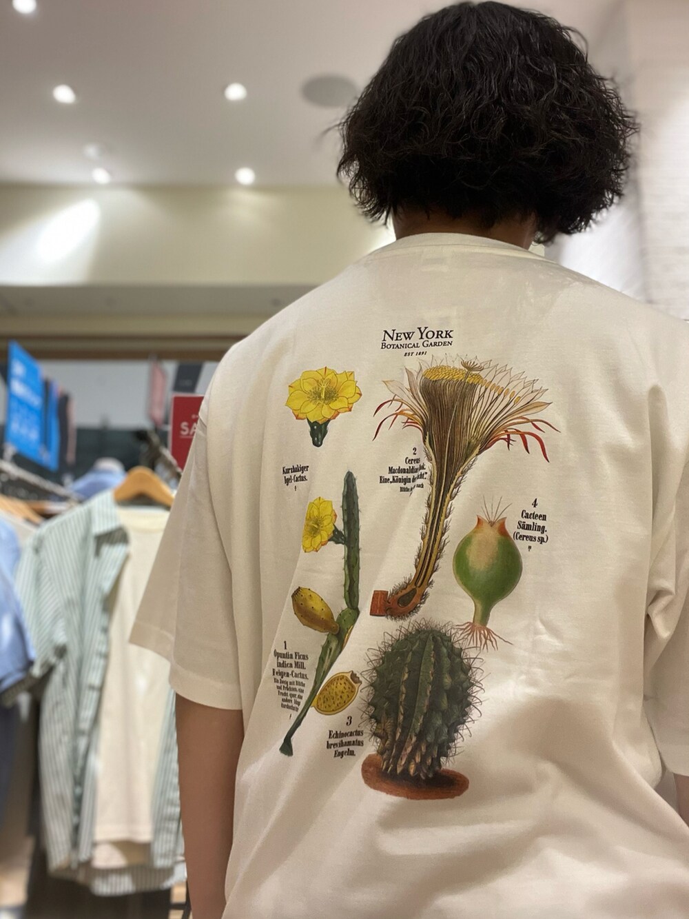 ホワイト系のTシャツ/カットソー、グリーン系のカーゴパンツを着用したメンズの夏コーディネートの2枚目の写真