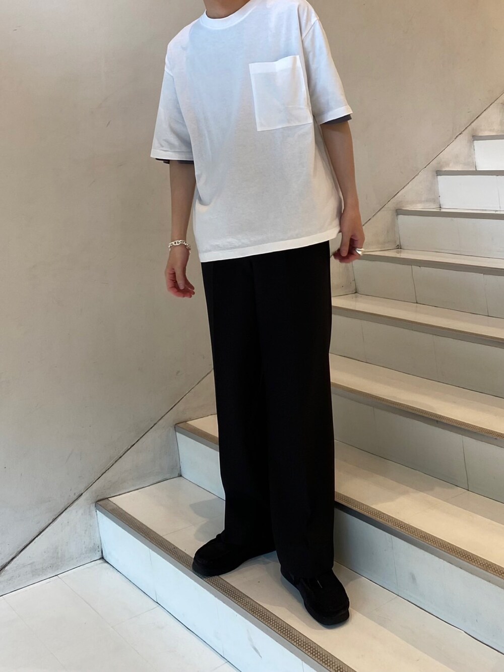 ホワイト系のTシャツ/カットソー、ブラック系のスラックスを着用したメンズの夏コーディネートの2枚目の写真