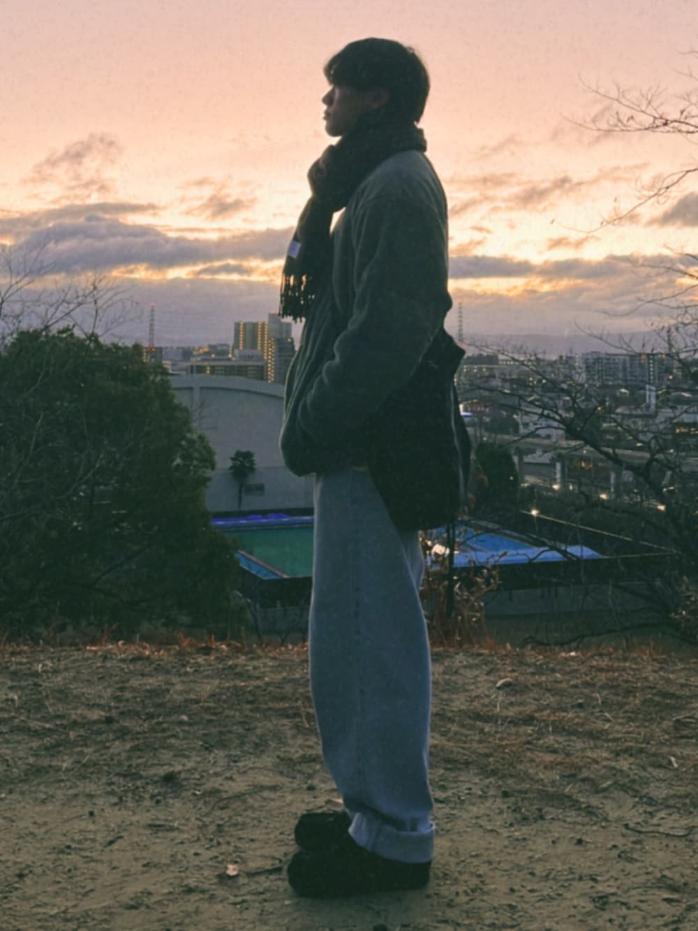 ブルー系のデニムパンツ、グリーン系のミリタリージャケット、ブラック系のモカシン/デッキシューズを着用したメンズの冬コーディネートの2枚目の写真