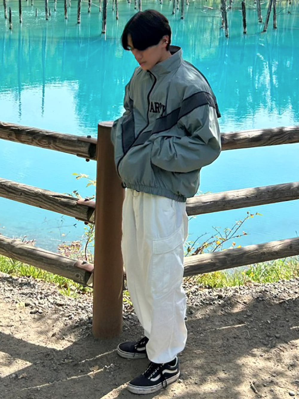 グリーン系のミリタリージャケット、ブラック系のスニーカー、ホワイト系のカーゴパンツを着用したメンズの冬コーディネートの2枚目の写真