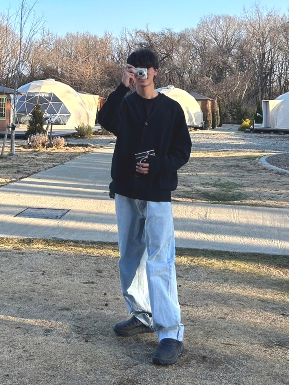 ブルー系のデニムパンツ、ブラック系のシューズを着用したメンズの春コーディネートの2枚目の写真