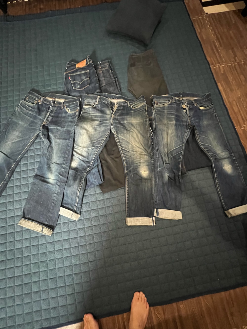 ブルー系のデニムパンツ、ブラック系のチノパンツ、ブルー系のカーゴパンツを着用したメンズの秋コーディネートの2枚目の写真