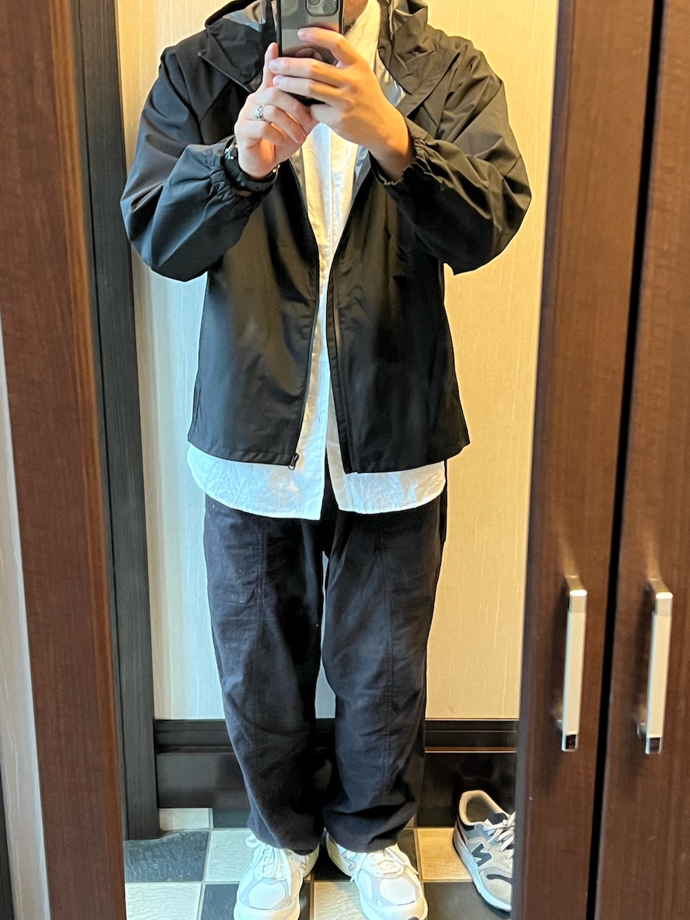 ブラック系のセットアップ、ホワイト系のスニーカー、ホワイト系のシャツ/ブラウスを着用したメンズの秋コーディネートの3枚目の写真