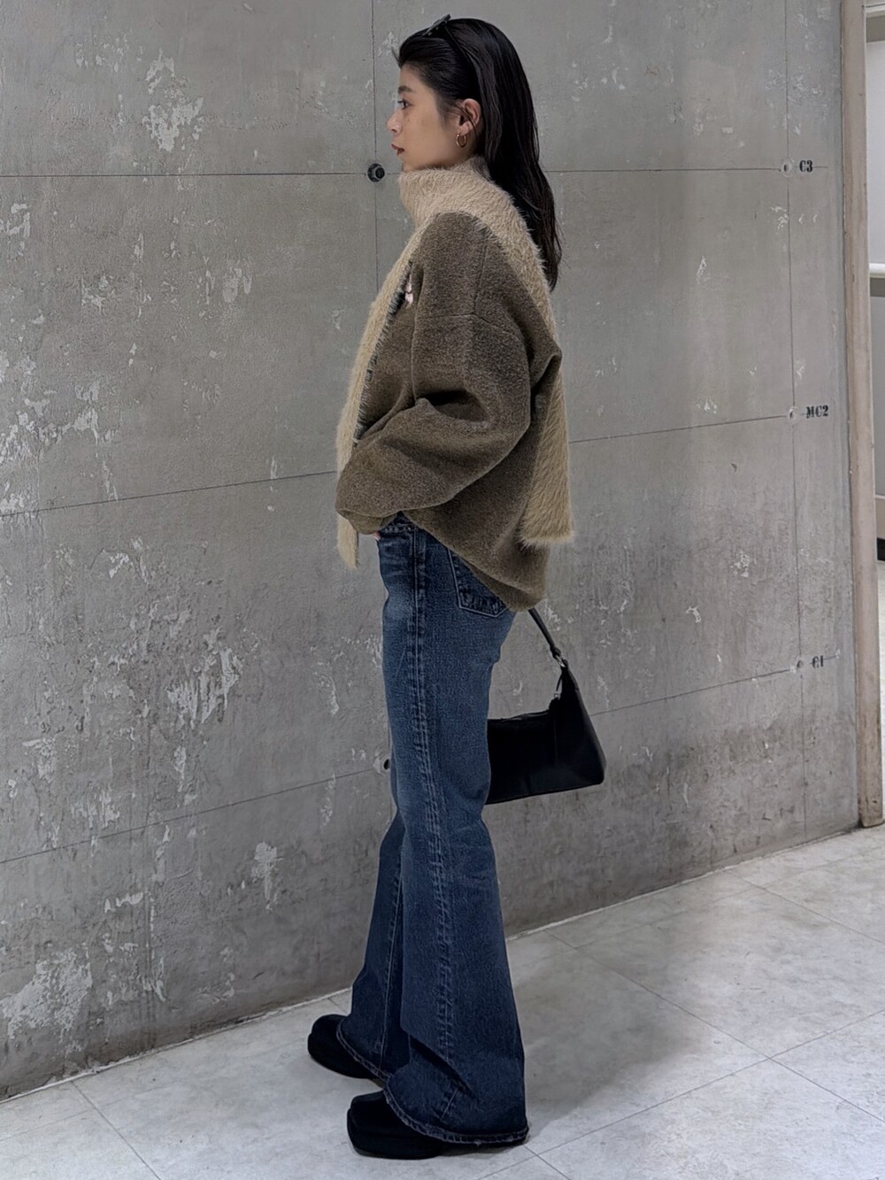 ブラウン系のニット/セーター、ブラック系のショルダーバッグ、ブラック系のブーツを着用したレディースの冬コーディネートの7枚目の写真