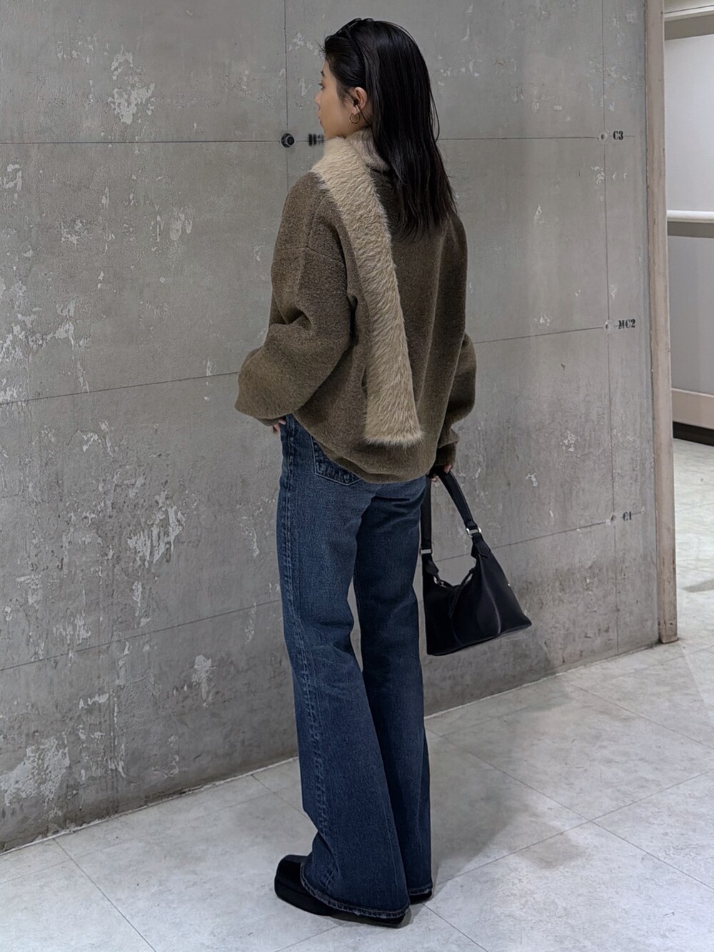 ブラウン系のニット/セーター、ブラック系のショルダーバッグ、ブラック系のブーツを着用したレディースの冬コーディネートの6枚目の写真