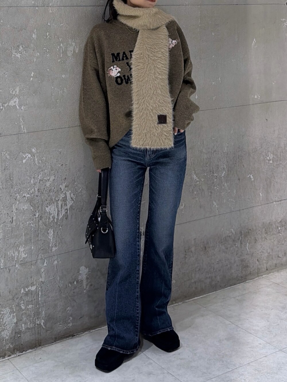 ブラウン系のニット/セーター、ブラック系のショルダーバッグ、ブラック系のブーツを着用したレディースの冬コーディネートの3枚目の写真