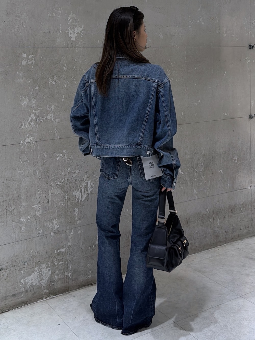 ブラック系のショルダーバッグ、ブルー系のデニムパンツ、ブルー系のデニムジャケットを着用したレディースの春コーディネートの4枚目の写真
