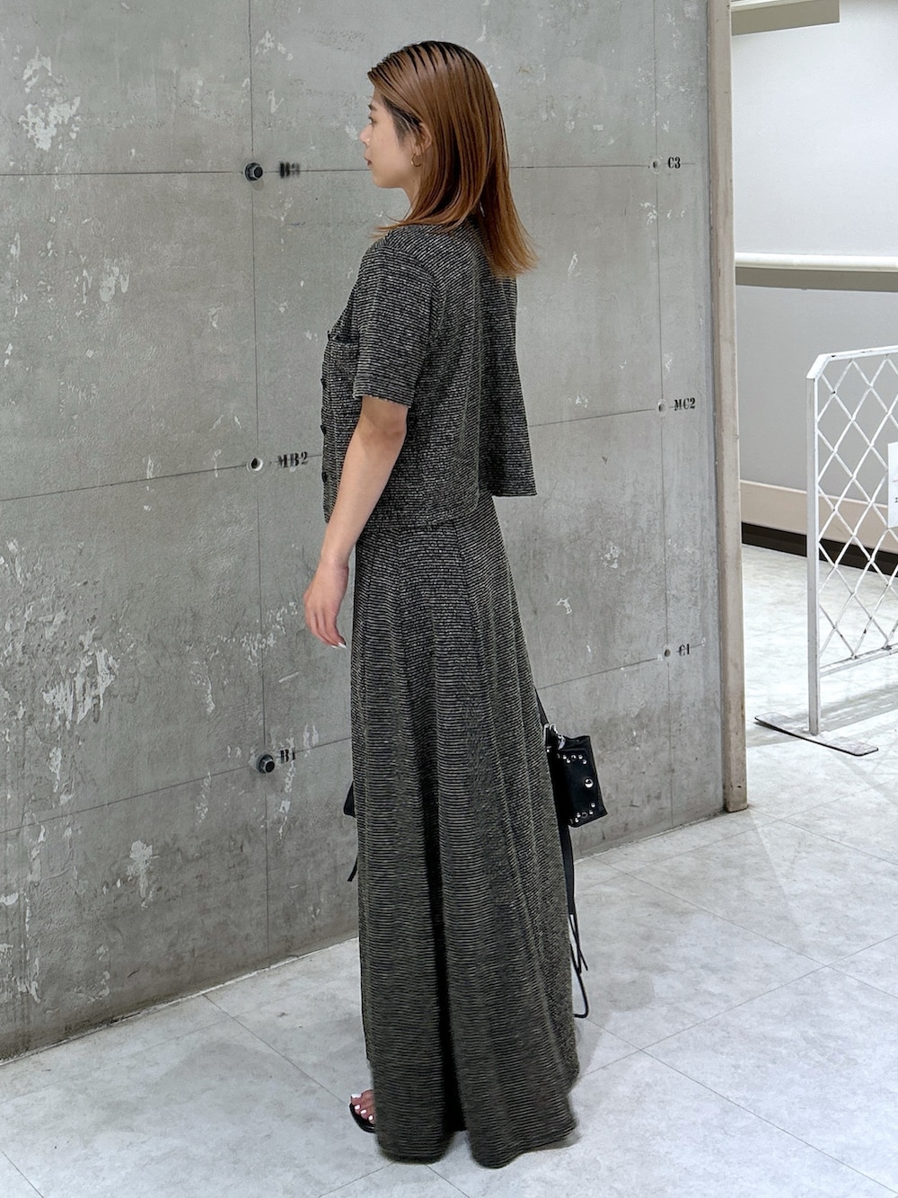 ブラック系のサンダル、ブラック系のワンピース、ブラック系のカーディガン/ボレロを着用したレディースの夏コーディネートの7枚目の写真