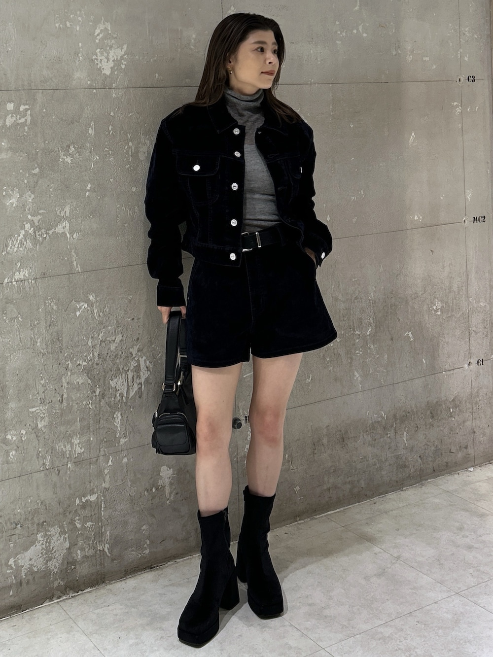 ブラック系のショルダーバッグ、ブラック系のブーツ、ブルー系のブルゾンを着用したレディースの秋コーディネートの3枚目の写真