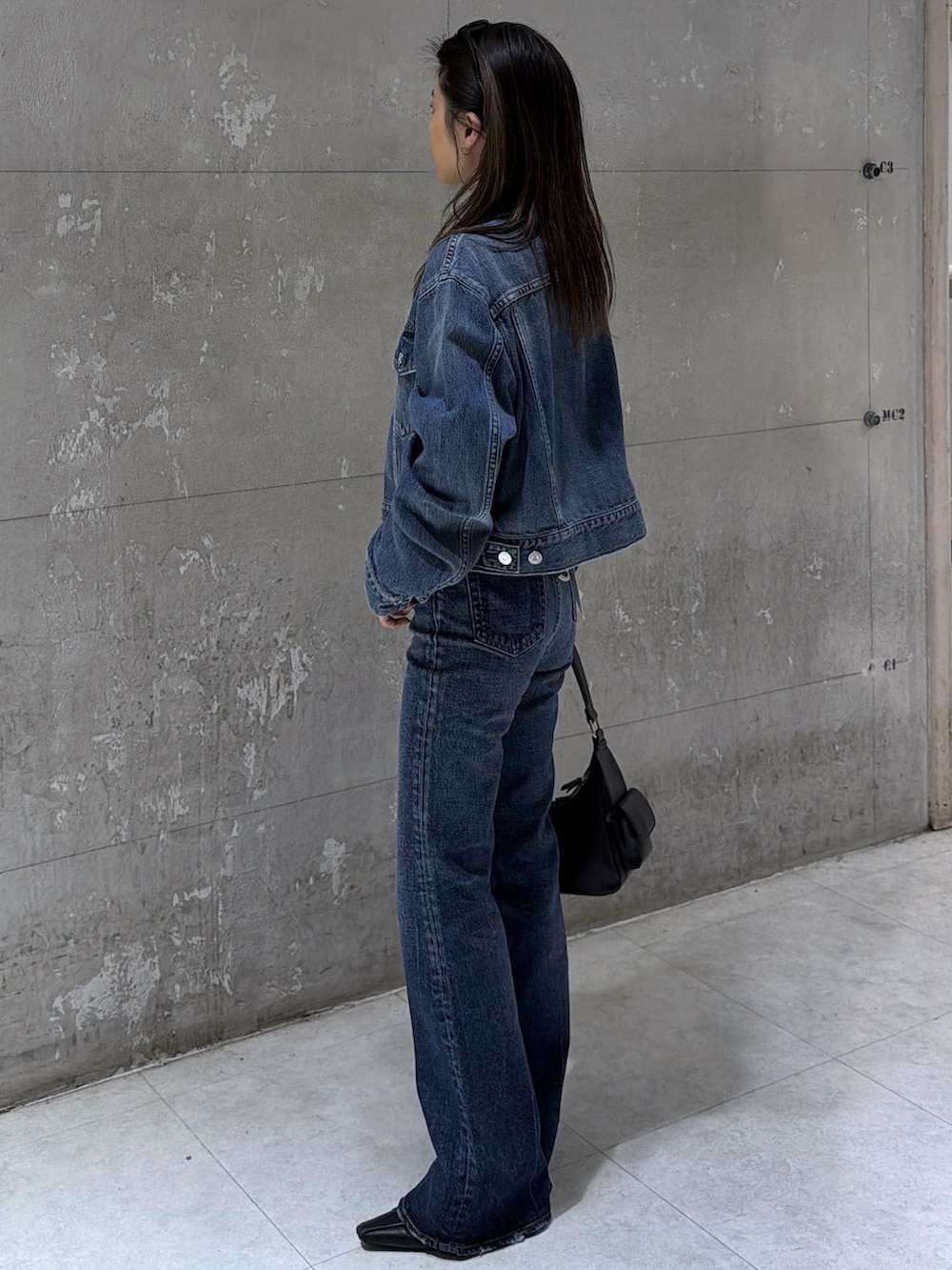 ブラック系のショルダーバッグ、ブルー系のデニムパンツ、ブルー系のデニムジャケットを着用したレディースの春コーディネートの5枚目の写真