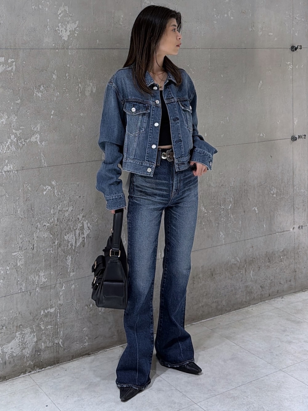 ブラック系のショルダーバッグ、ブルー系のデニムパンツ、ブルー系のデニムジャケットを着用したレディースの春コーディネートの2枚目の写真