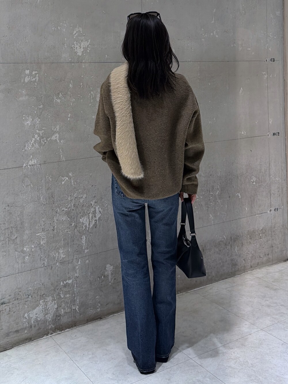 ブラウン系のニット/セーター、ブラック系のショルダーバッグ、ブラック系のブーツを着用したレディースの冬コーディネートの5枚目の写真