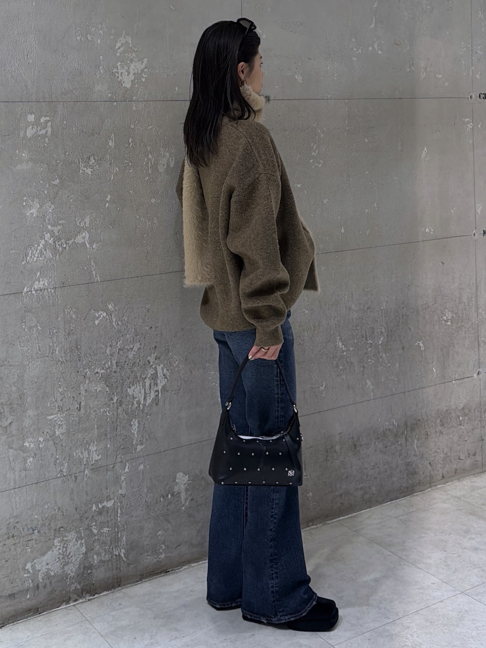 ブラウン系のニット/セーター、ブラック系のショルダーバッグ、ブラック系のブーツを着用したレディースの冬コーディネートの4枚目の写真