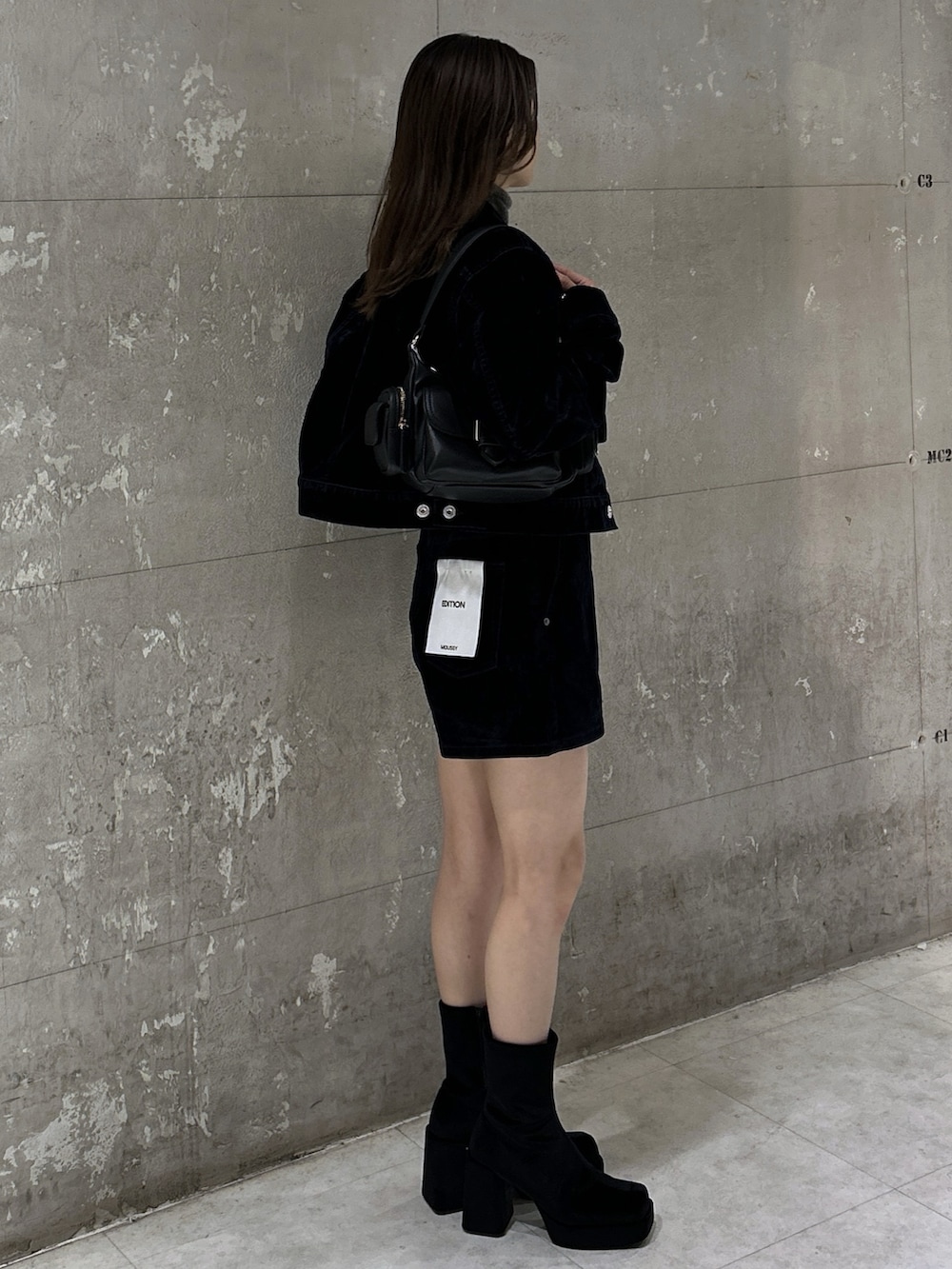 ブラック系のショルダーバッグ、ブラック系のブーツ、ブルー系のブルゾンを着用したレディースの秋コーディネートの5枚目の写真