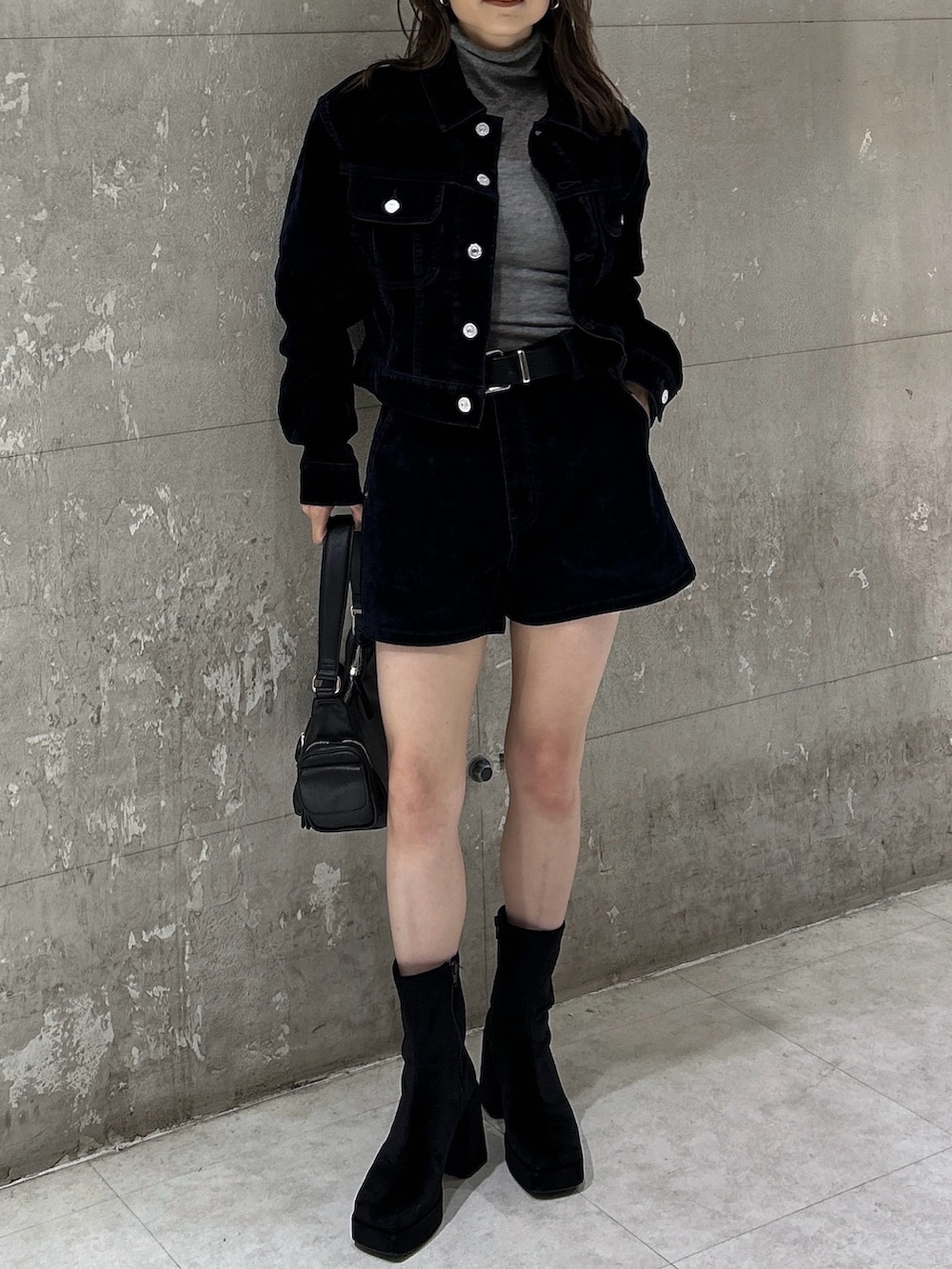 ブラック系のショルダーバッグ、ブラック系のブーツ、ブルー系のブルゾンを着用したレディースの秋コーディネートの2枚目の写真