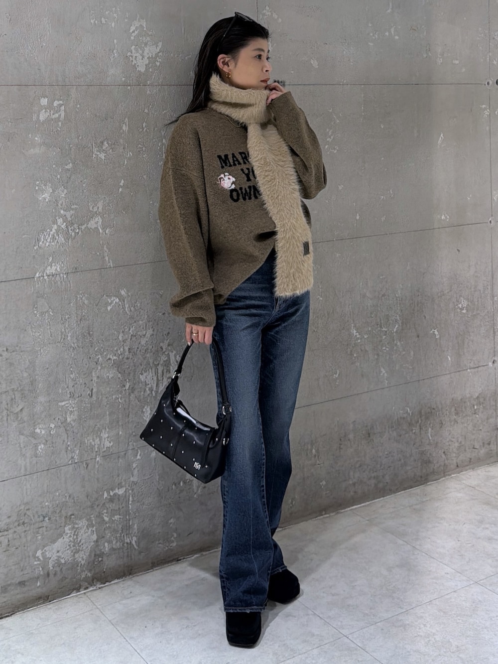 ブラウン系のニット/セーター、ブラック系のショルダーバッグ、ブラック系のブーツを着用したレディースの冬コーディネートの2枚目の写真