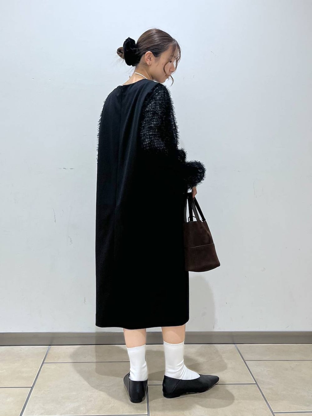 ブラック系のシャツ/ブラウス、ブラック系のワンピース、ブラウン系のハンドバッグを着用したレディースの冬コーディネートの3枚目の写真