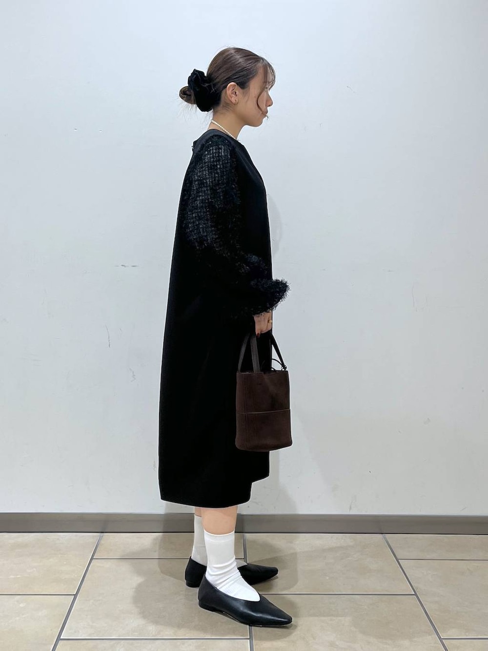 ブラック系のシャツ/ブラウス、ブラック系のワンピース、ブラウン系のハンドバッグを着用したレディースの冬コーディネートの2枚目の写真