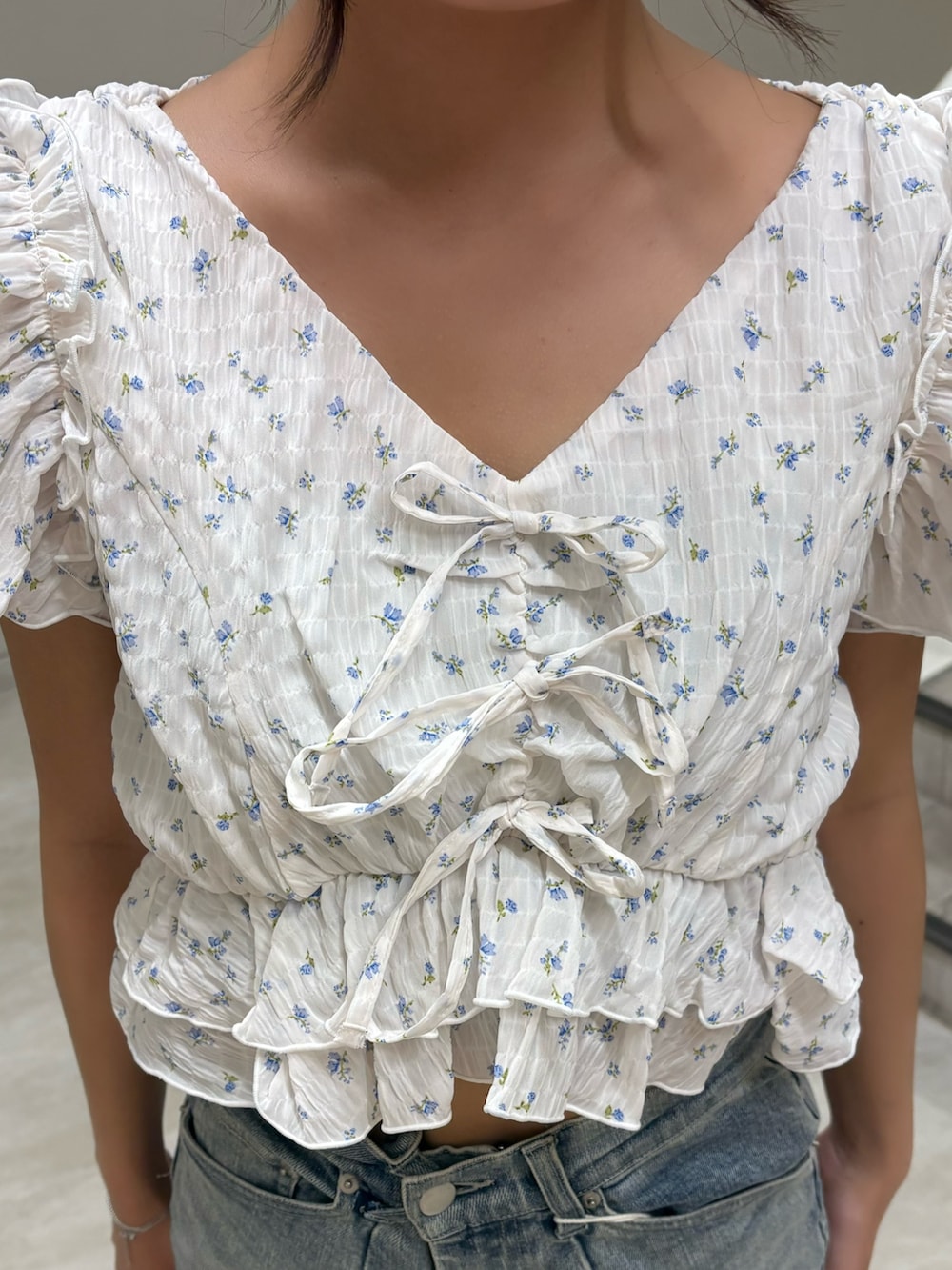 ホワイト系のシャツ/ブラウス、ブルー系のデニムパンツ、ホワイト系のサンダルを着用したレディースの夏コーディネートの4枚目の写真