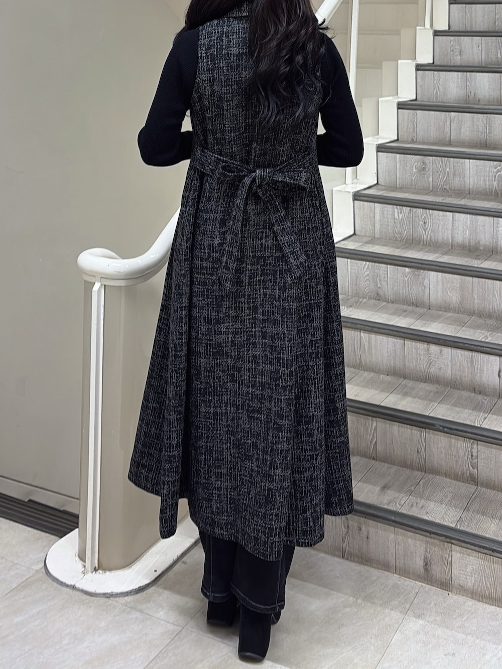 ブラック系のトレンチコート、ブラック系のブーツを着用したレディースの冬コーディネートの6枚目の写真