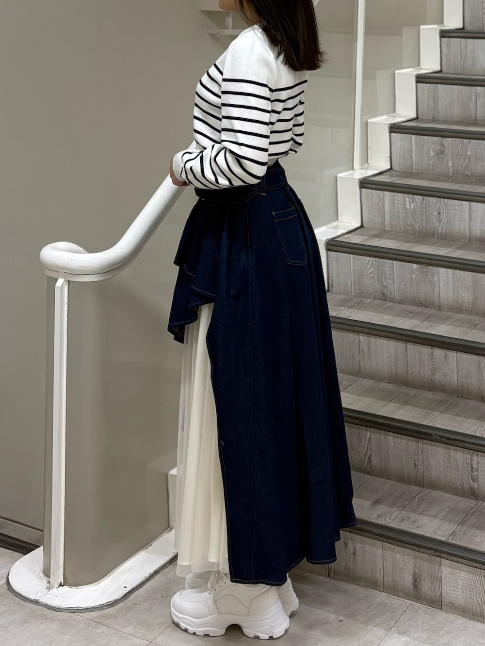 ホワイト系のカーディガン/ボレロ、ブルー系のスカート、ホワイト系のスニーカーを着用したレディースの春コーディネートの2枚目の写真