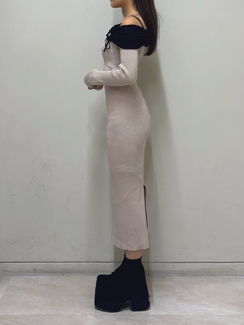 ベージュ系のワンピース、ブラック系のブーツを着用したレディースの秋コーディネートの2枚目の写真