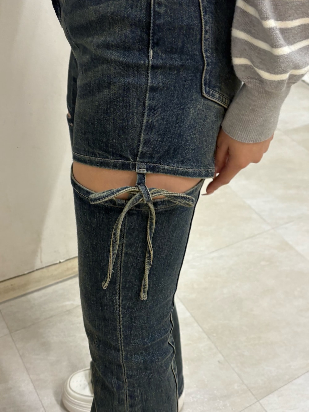 グレー系のカーディガン/ボレロ、ブルー系のデニムパンツを着用したレディースの春コーディネートの5枚目の写真