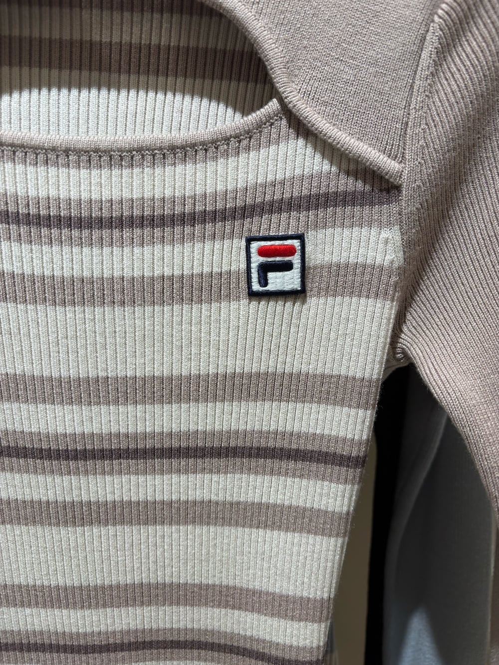 ベージュ系のワンピース、ピンク系のボストンバッグ、ブラック系のブーツを着用したレディースの冬コーディネートの4枚目の写真