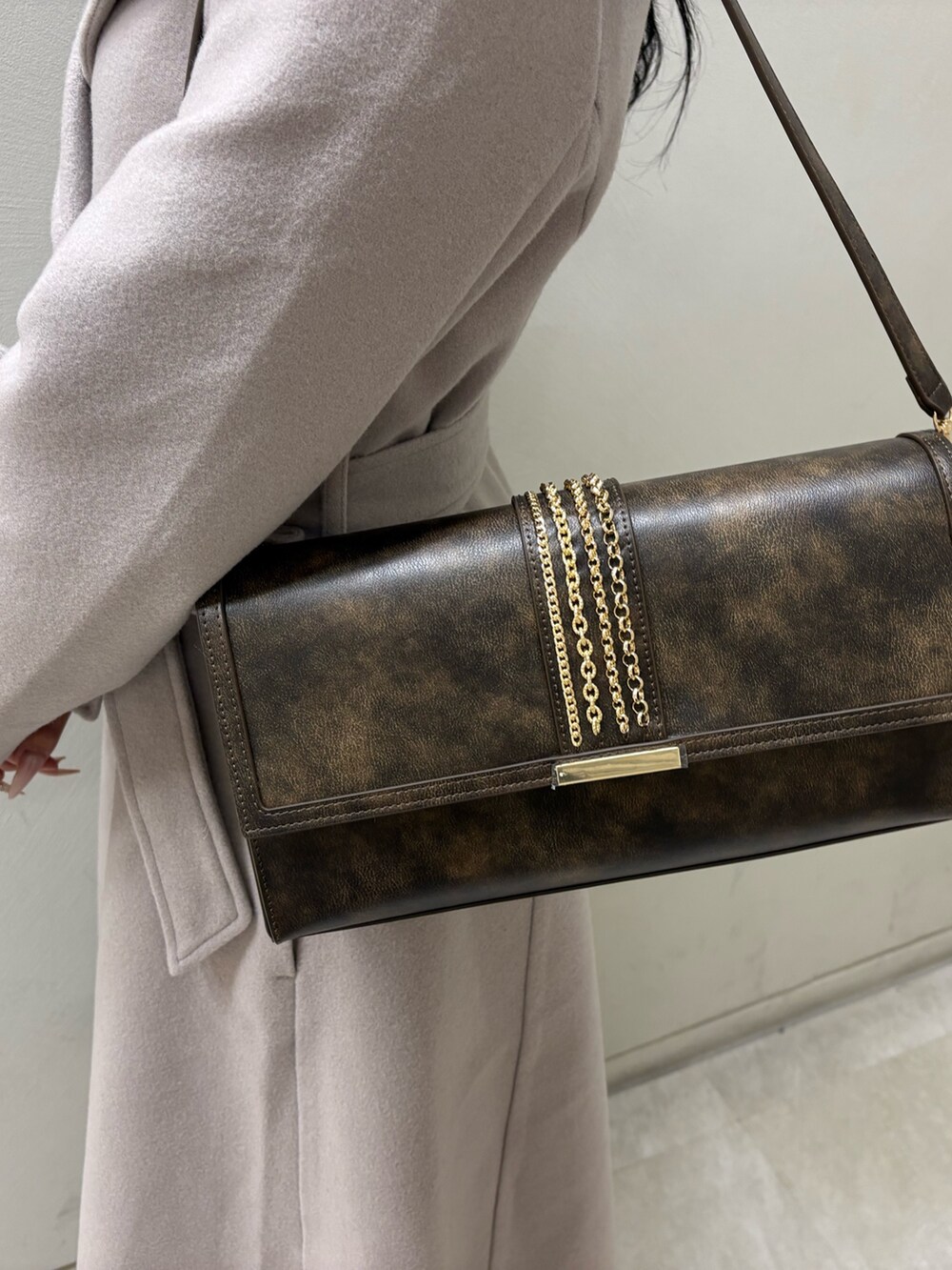 ベージュ系のその他アウター、ブラック系のブーツ、ブラウン系のハンドバッグを着用したレディースの冬コーディネートの4枚目の写真