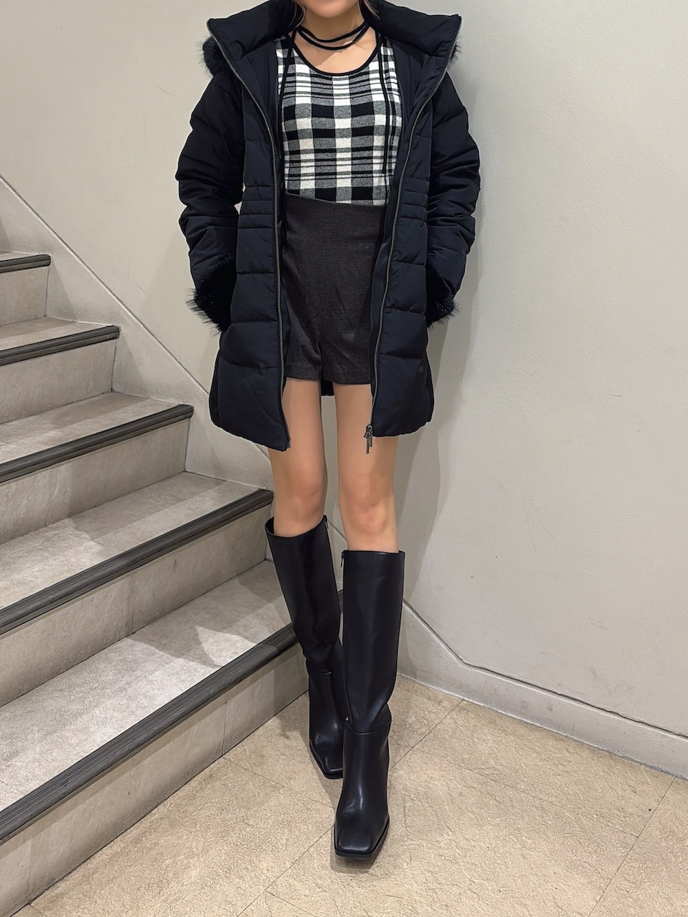 ブラック系のブーツ、ブラック系のダウンジャケット/コート、その他のニット/セーターを着用したレディースの夏コーディネートの2枚目の写真