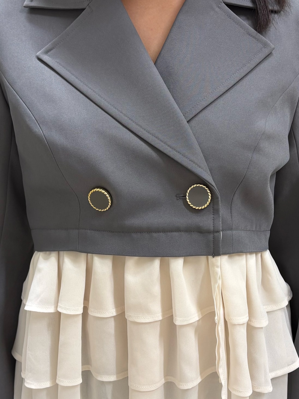 グレー系のその他アウター、ブルー系のデニムパンツ、ホワイト系のパンプスを着用したレディースの春コーディネートの4枚目の写真