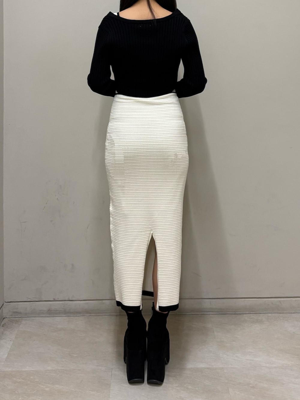 ホワイト系のワンピース、ブラック系のブーツを着用したレディースの春コーディネートの3枚目の写真