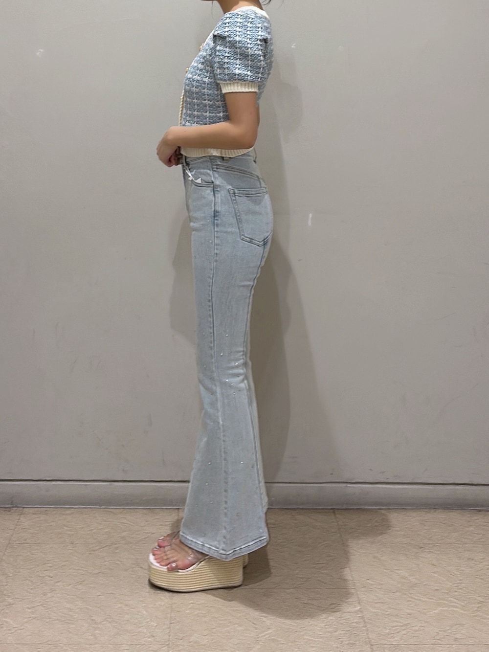 ブルー系のニット/セーター、ブルー系のデニムパンツ、ホワイト系のサンダルを着用したレディースの春コーディネートの2枚目の写真