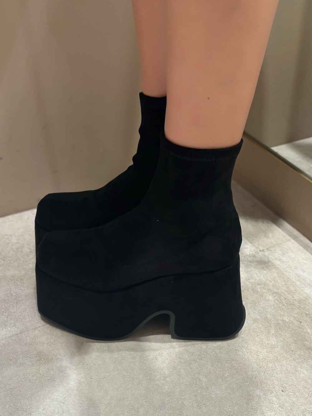 ベージュ系のその他アウター、ブラック系のブーツ、ブラウン系のハンドバッグを着用したレディースの冬コーディネートの5枚目の写真