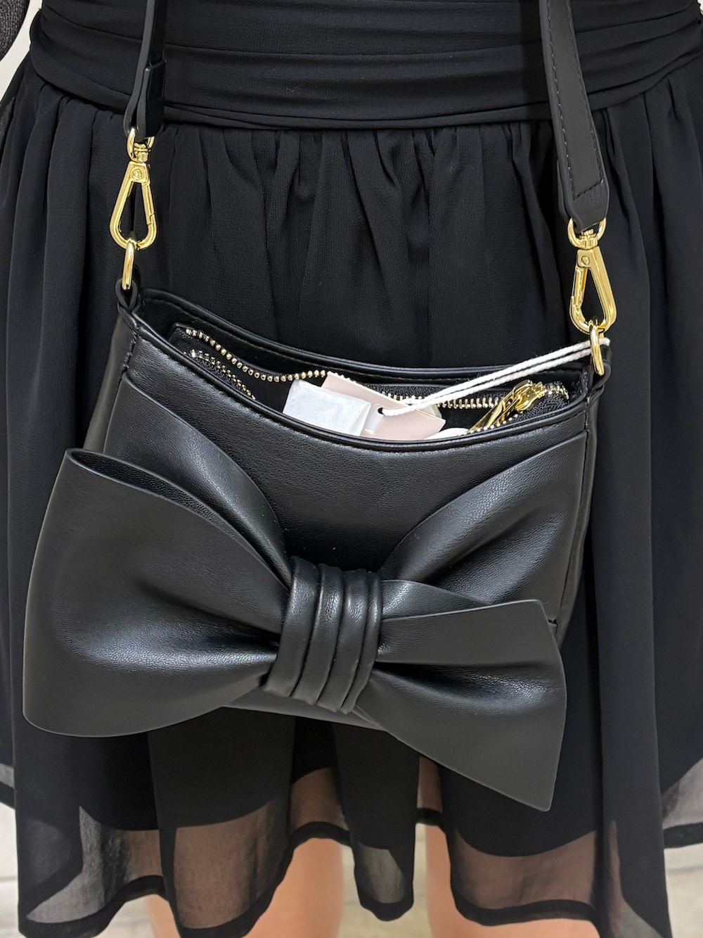 ブラック系のワンピース、ブラック系のブーツ、ブラック系のハンドバッグを着用したレディースの春コーディネートの4枚目の写真