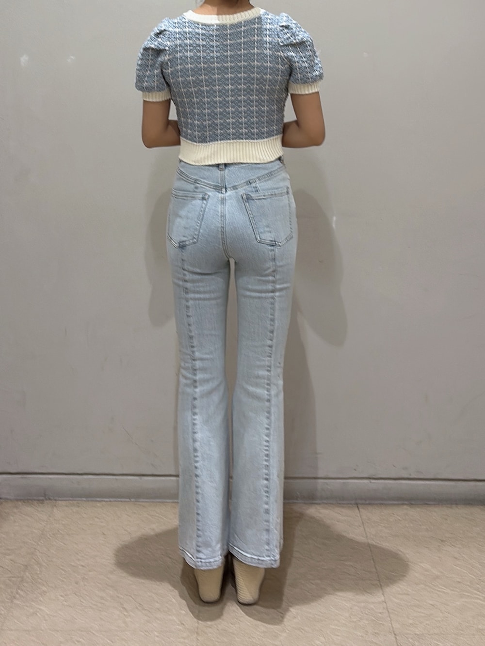 ブルー系のニット/セーター、ブルー系のデニムパンツ、ホワイト系のサンダルを着用したレディースの春コーディネートの3枚目の写真