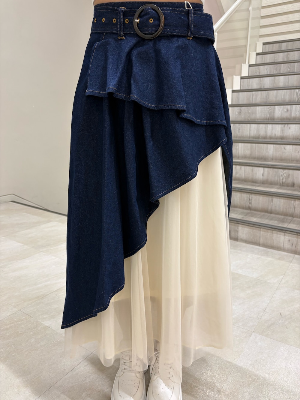 ホワイト系のカーディガン/ボレロ、ブルー系のスカート、ホワイト系のスニーカーを着用したレディースの春コーディネートの4枚目の写真