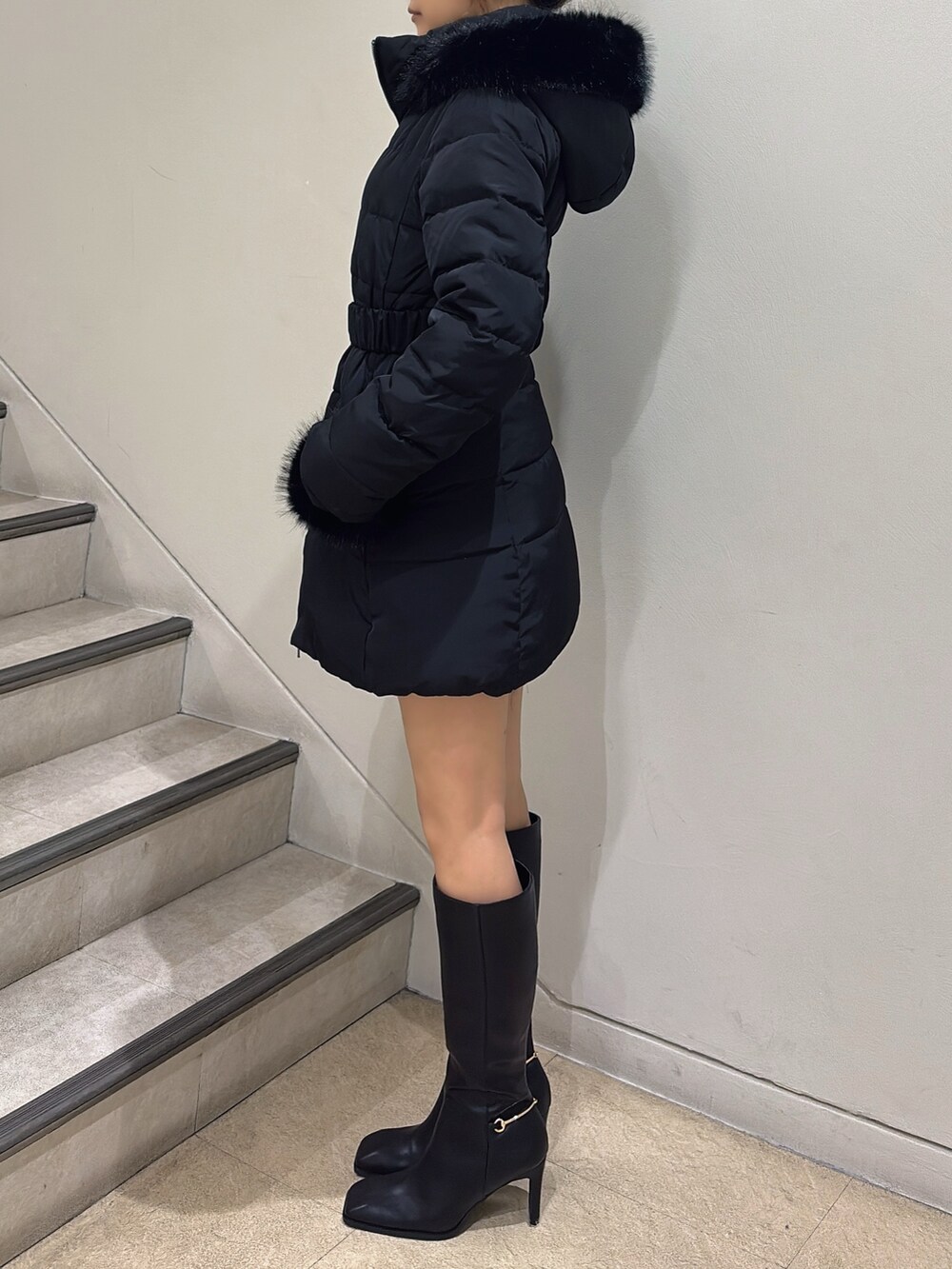 ブラック系のブーツ、ブラック系のダウンジャケット/コート、その他のニット/セーターを着用したレディースの夏コーディネートの3枚目の写真