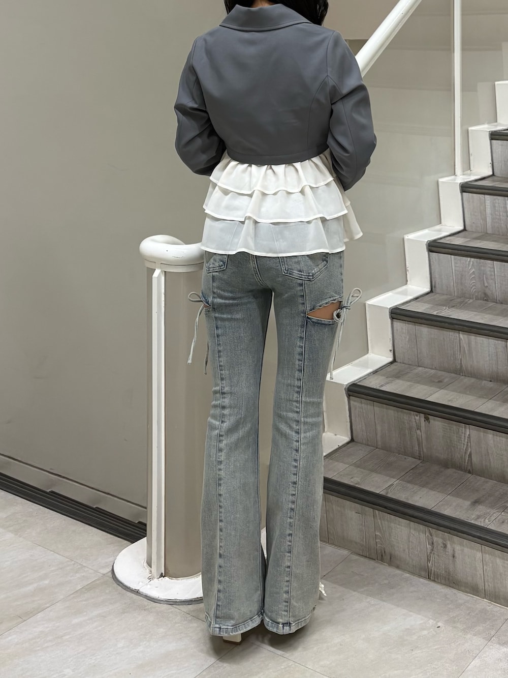 グレー系のその他アウター、ブルー系のデニムパンツ、ホワイト系のパンプスを着用したレディースの春コーディネートの3枚目の写真