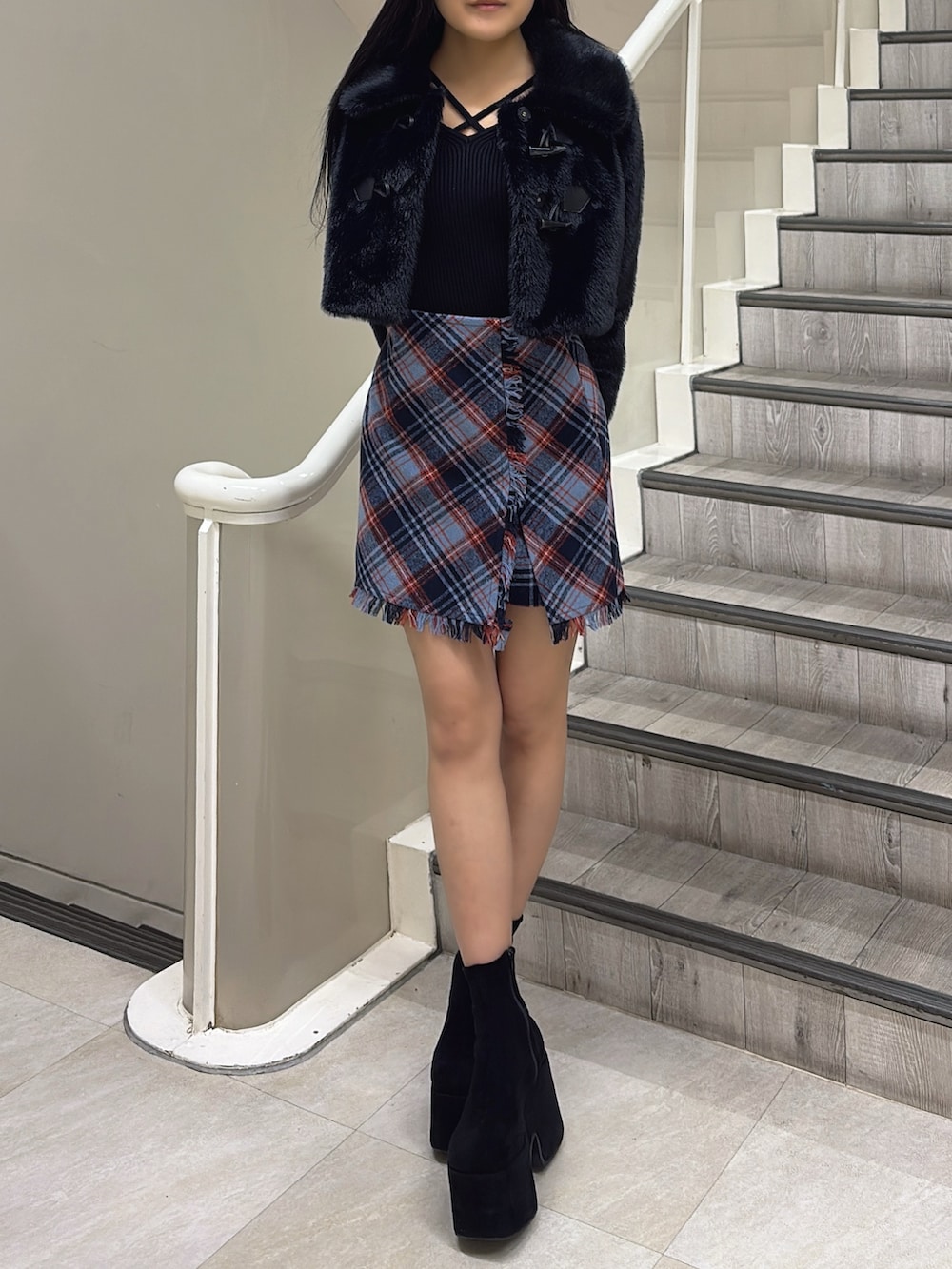 ブラック系のブルゾン、ブルー系のスカート、ブラック系のニット/セーターを着用したレディースの冬コーディネートの2枚目の写真