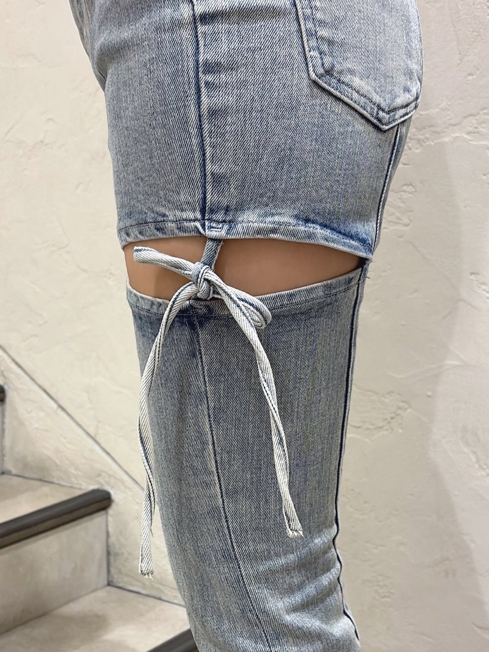 グレー系のニット/セーター、ブルー系のデニムパンツ、ホワイト系のサンダルを着用したレディースの春コーディネートの4枚目の写真