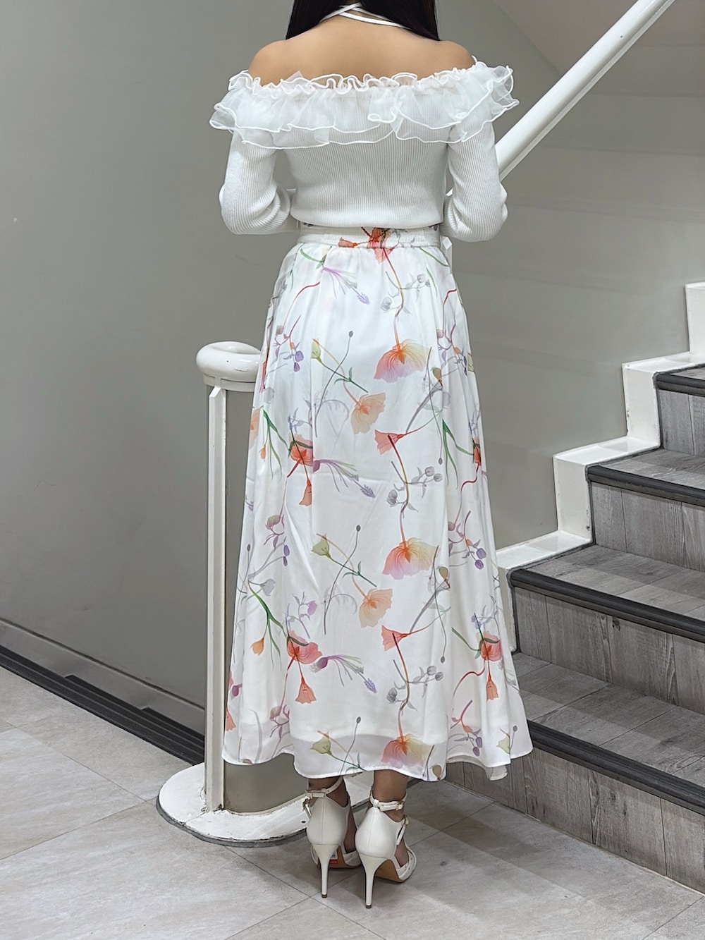 ホワイト系のニット/セーター、ホワイト系のスカート、ホワイト系のパンプスを着用したレディースの冬コーディネートの3枚目の写真