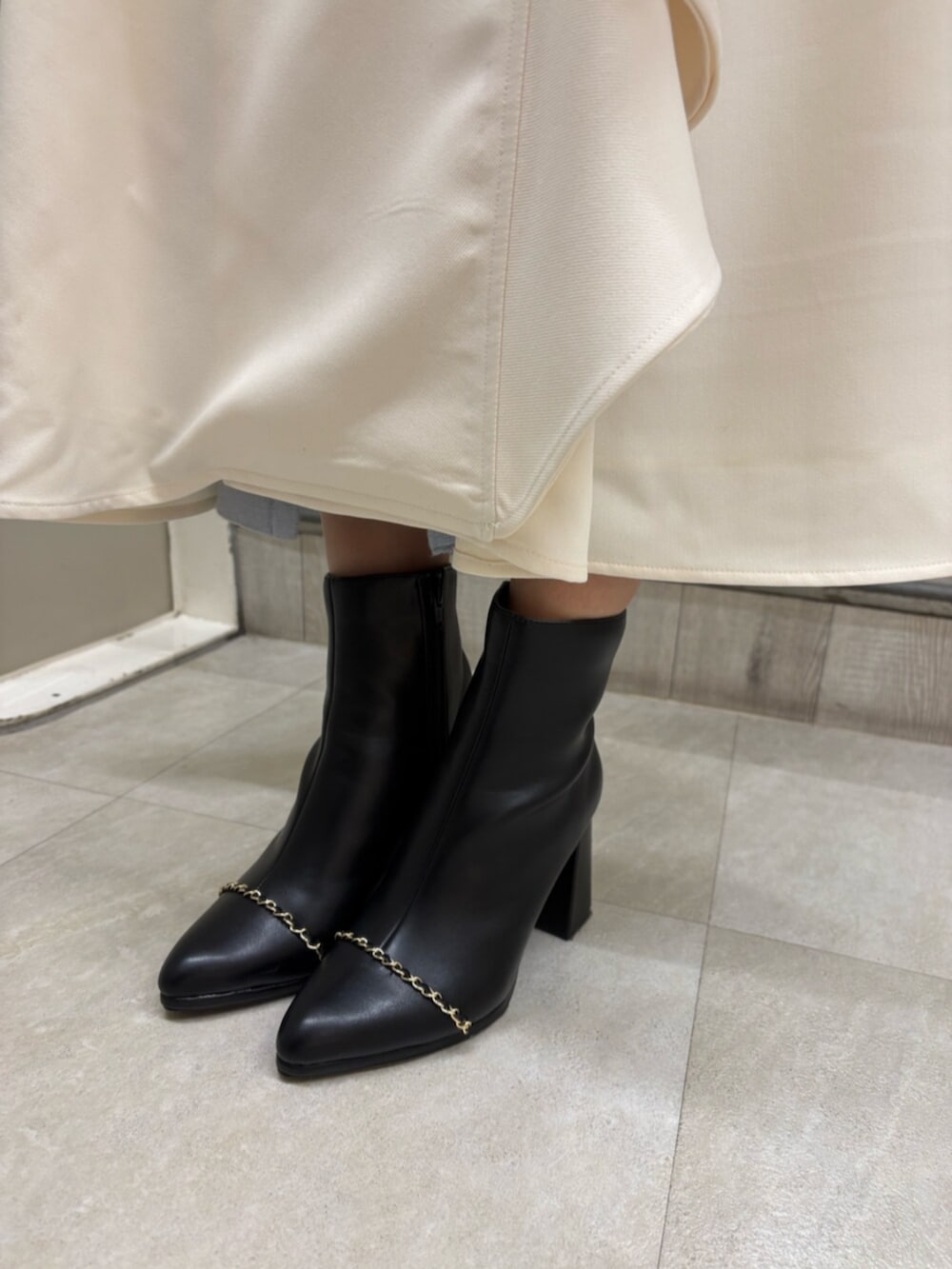 ブラック系のブーツ、ホワイト系のトレンチコートを着用したレディースの冬コーディネートの5枚目の写真